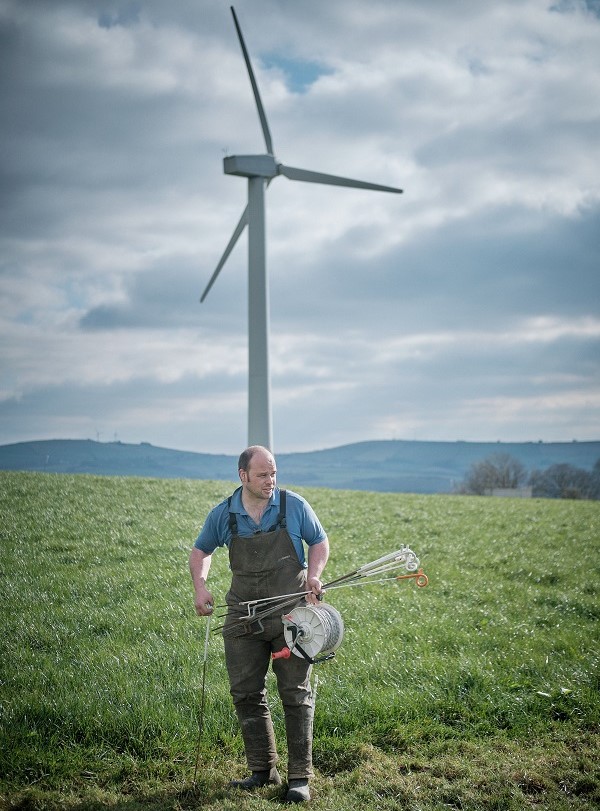 Marcus Ferraro standing in front of a wind turbine.